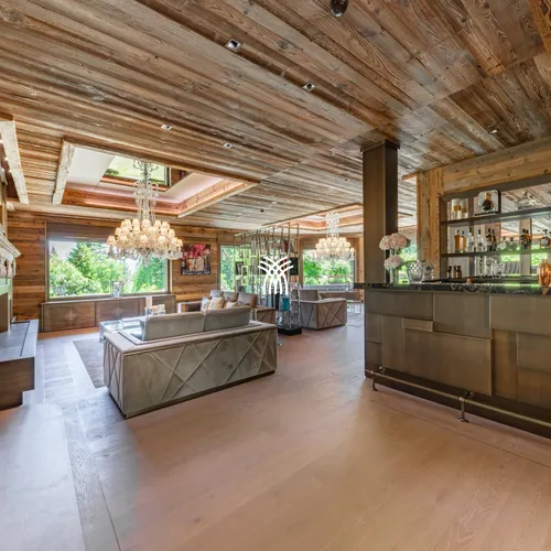 The open living room and bar of Chalet Christiana, under an old-wood ceiling.