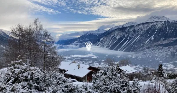 A snowy panorama over the Rhône valley and the Alps seen from Chalet Cervo in Crans-Montana.